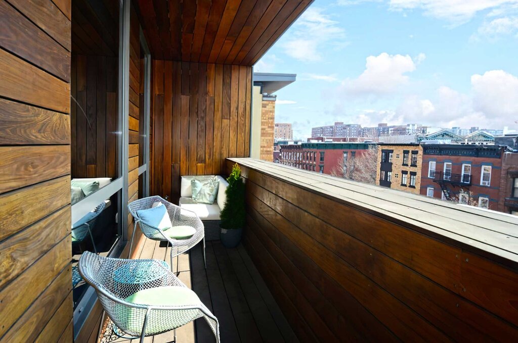 A balcony lined with clapboard