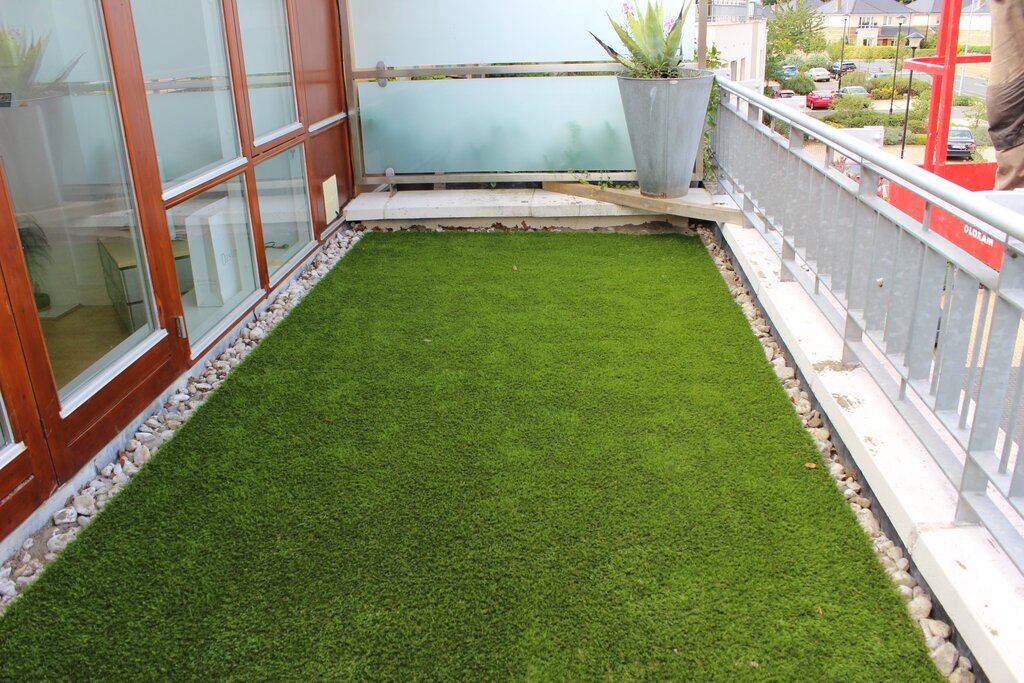 A balcony with artificial grass on the floor