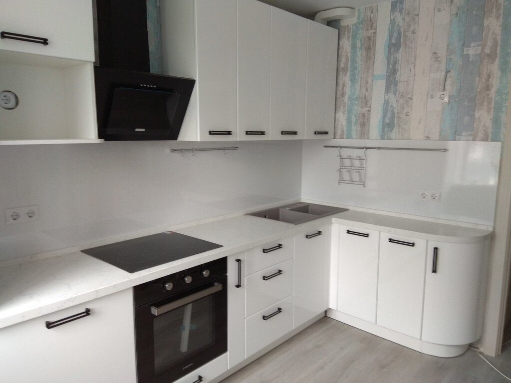 A white kitchen with black appliances