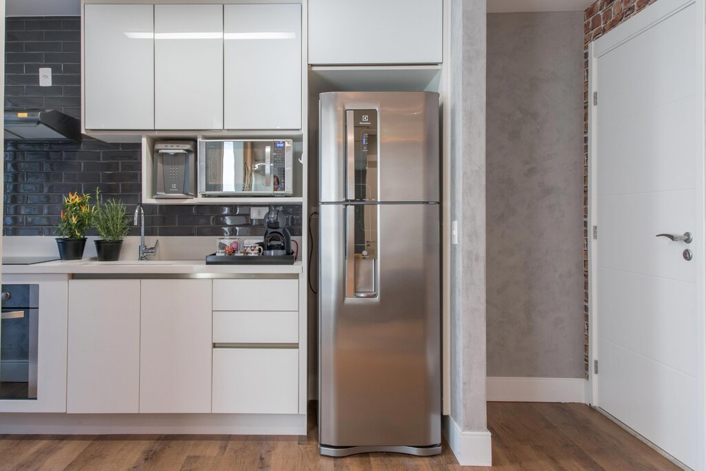 A white kitchen with a gray refrigerator