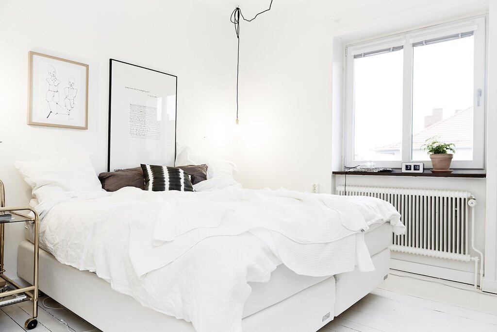 White wallpaper in the bedroom interior