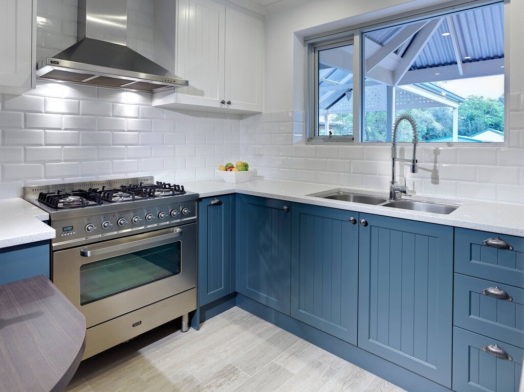 White and blue kitchen with a wooden countertop