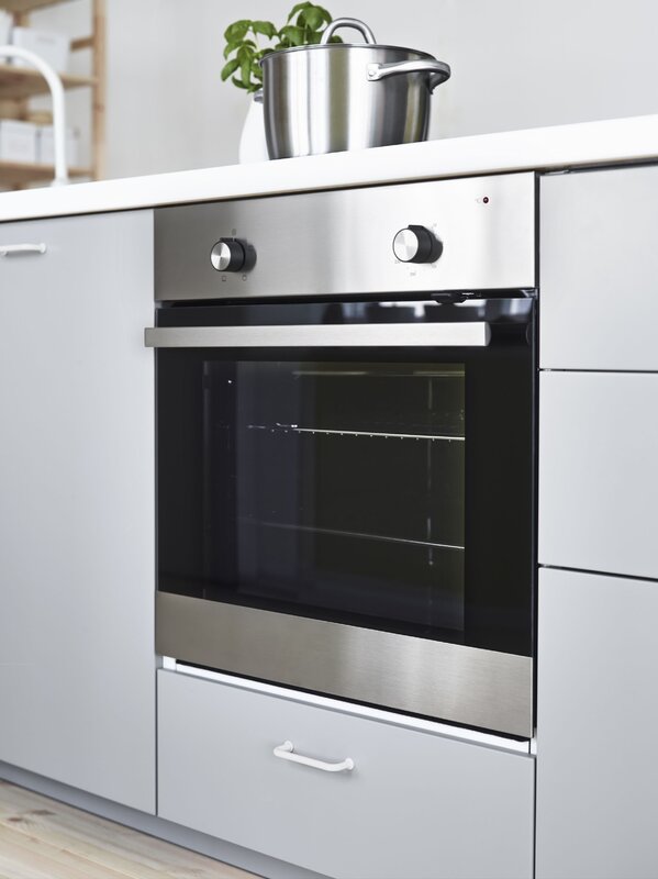 A black oven in a white kitchen