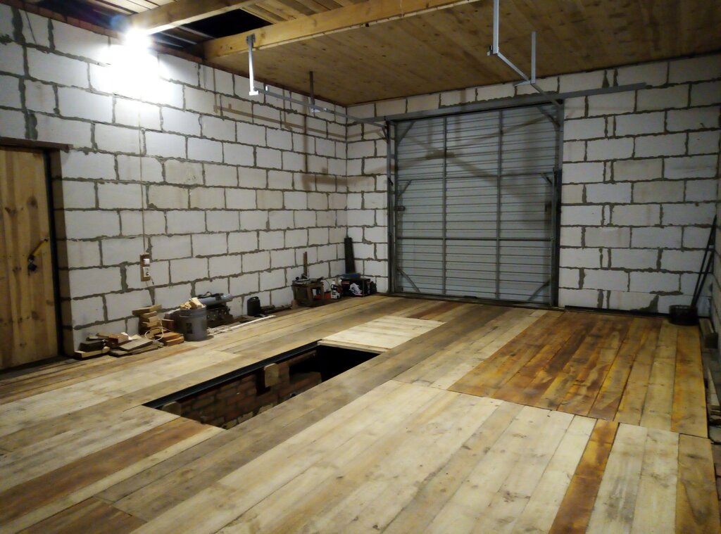 Wooden floor in the garage with a pit