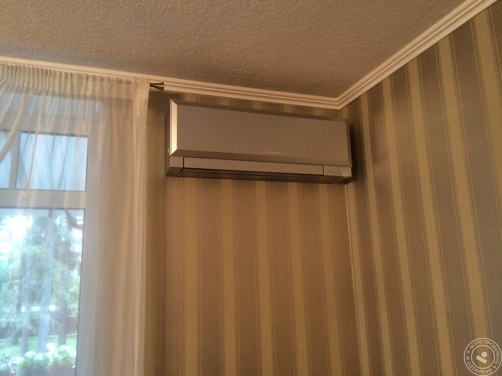 The air conditioner is behind the curtain