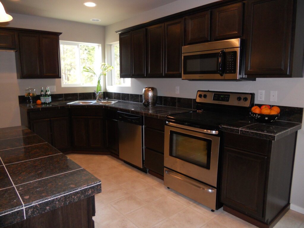 A brown kitchen with a black countertop