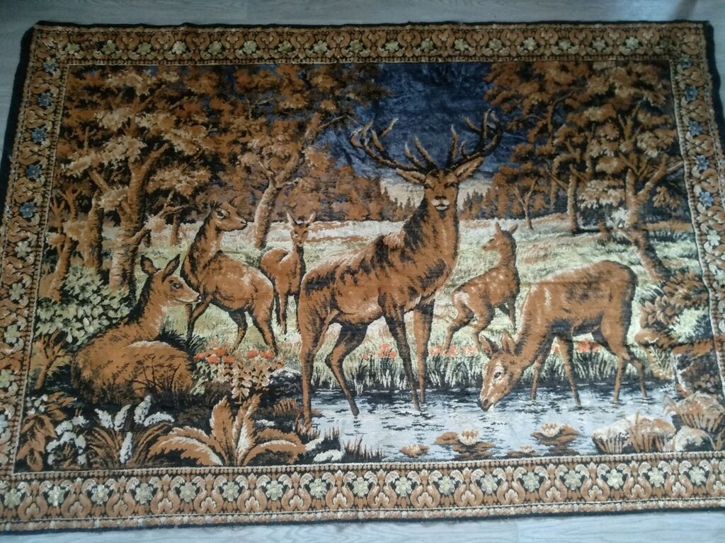 A rug on the wall with deer