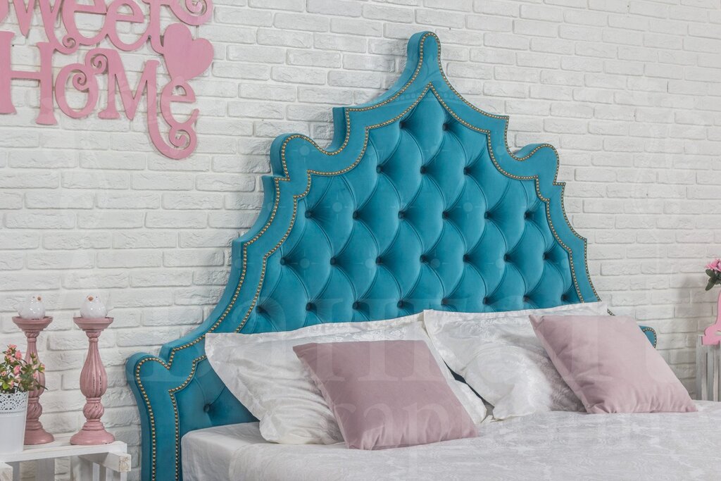 A turquoise bed with a soft headboard