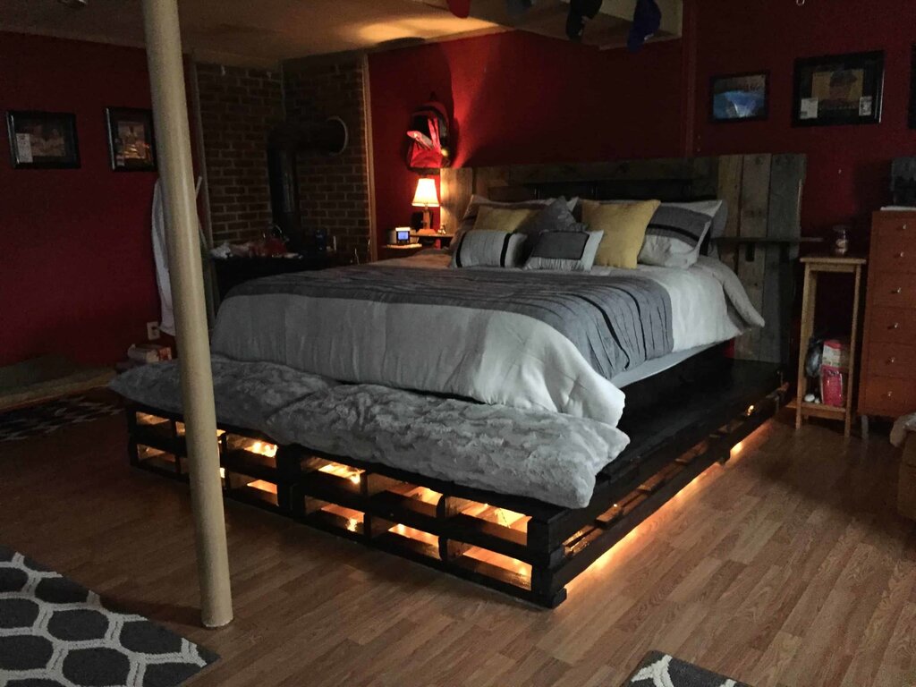 A bed made from pallets with lighting