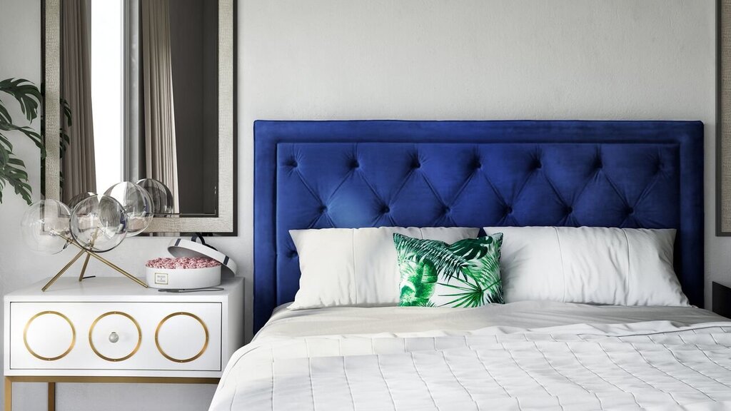 A bed with a blue headboard in the interior