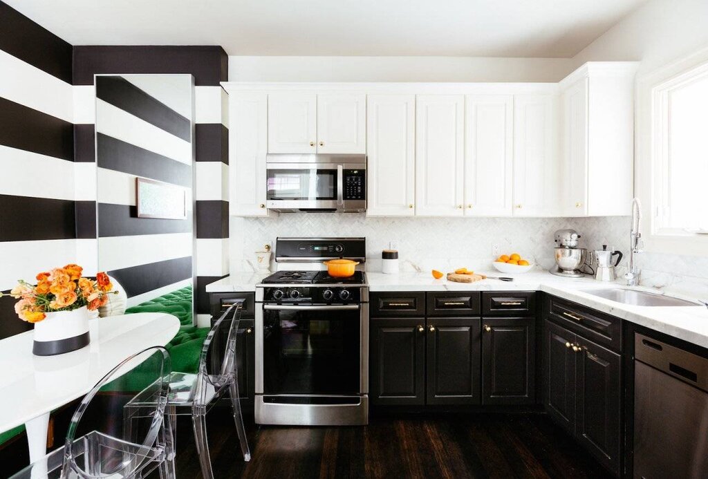 The kitchen has black lower cabinets and white upper cabinets