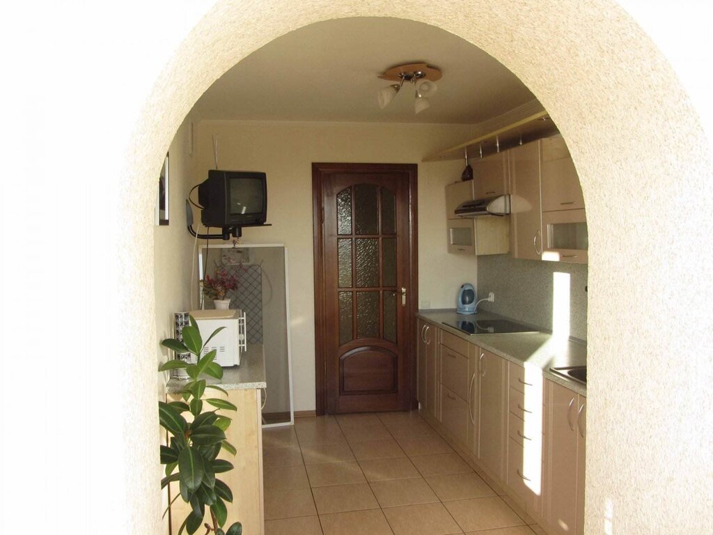 A kitchen with an archway to the balcony