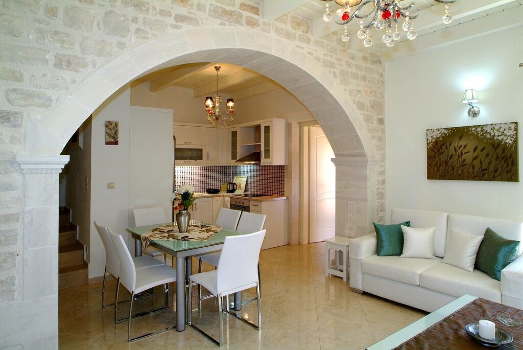 A kitchen with an archway to the living room