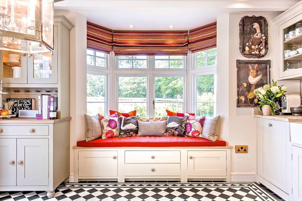 A kitchen with a small couch by the window