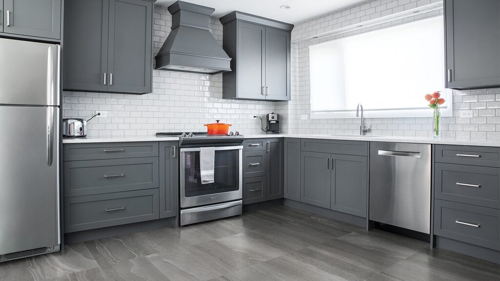 A kitchen with gray tiles on the floor