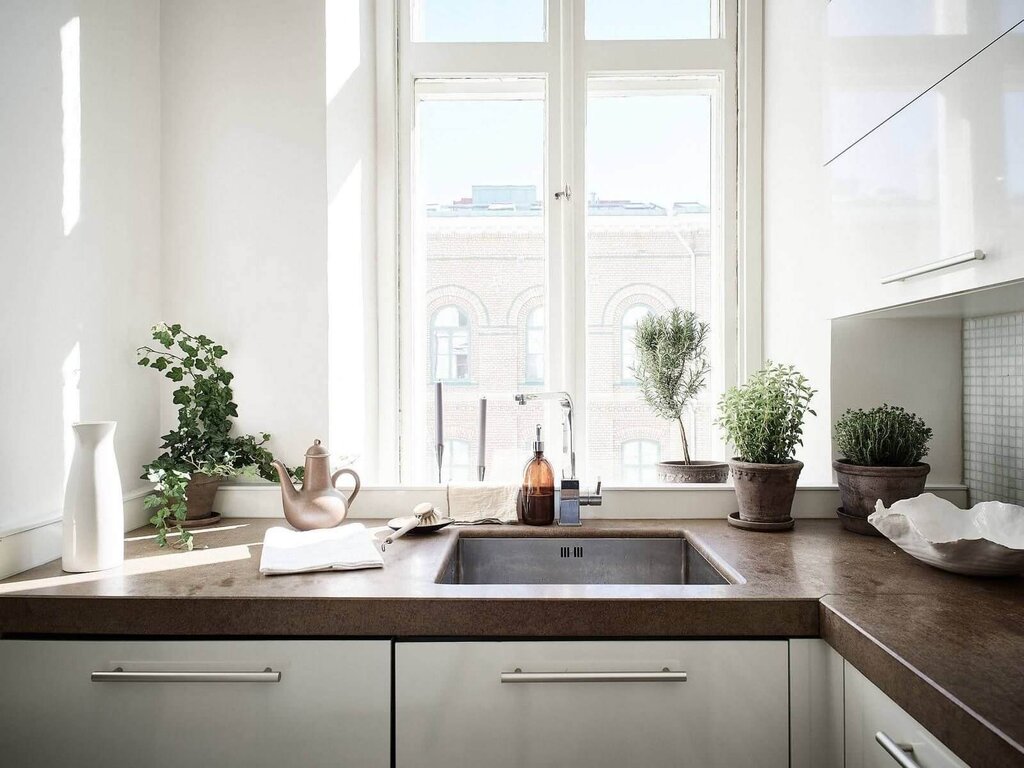 A kitchen set with a sink by the window