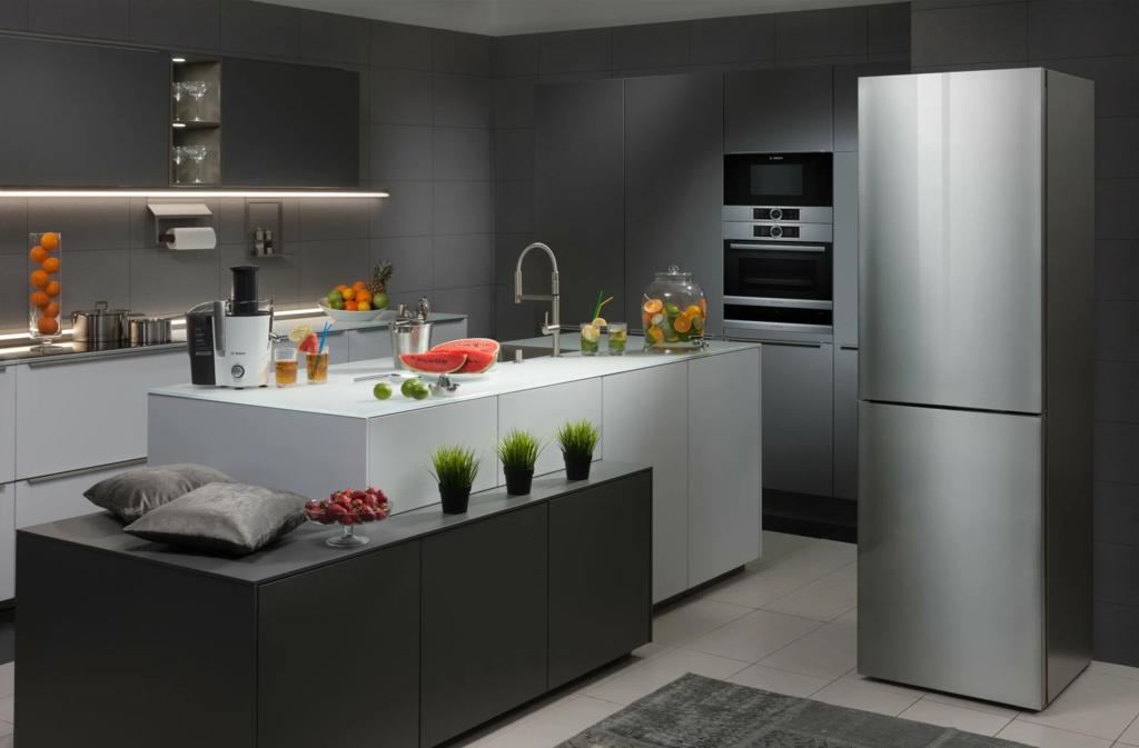 A gray refrigerator in the interior of a white kitchen