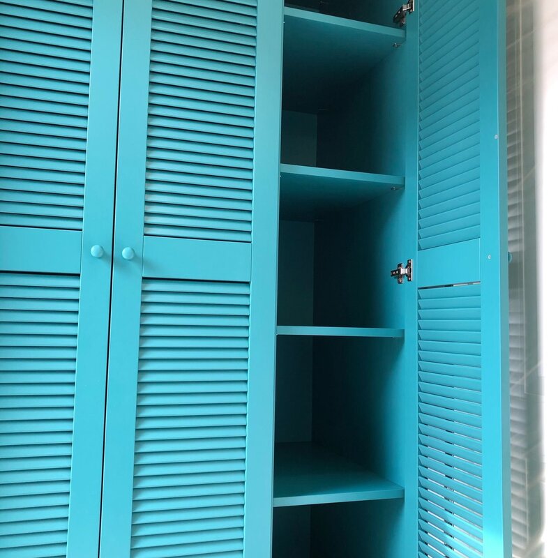 A cabinet with louvered doors