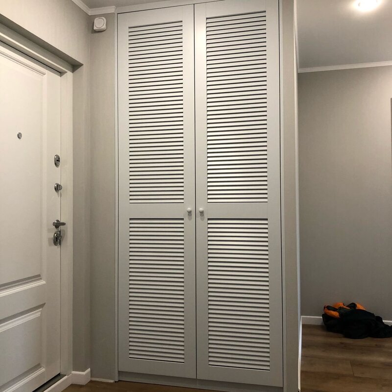 A cabinet on the balcony with louvered doors