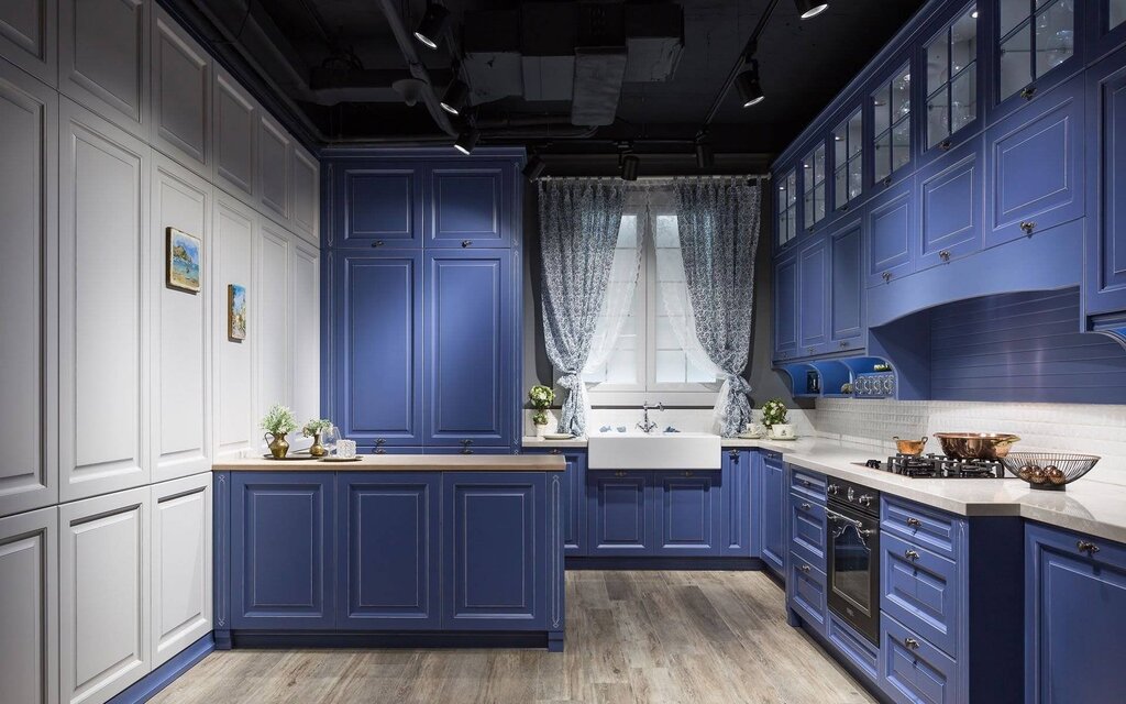 A blue kitchen with a white countertop