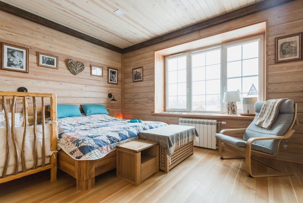 A bedroom paneled with clapboard