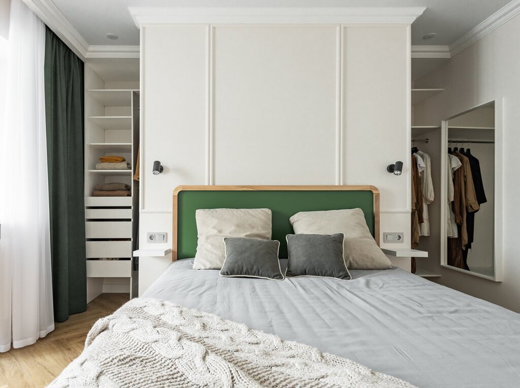 A bedroom with a walk-in closet behind the headboard of the bed