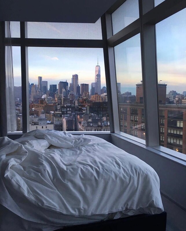 A bedroom with a view of the city