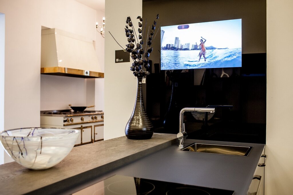 The television is in the kitchen above the table