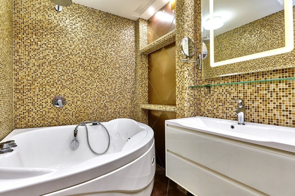 A bathtub with mosaic and tiles