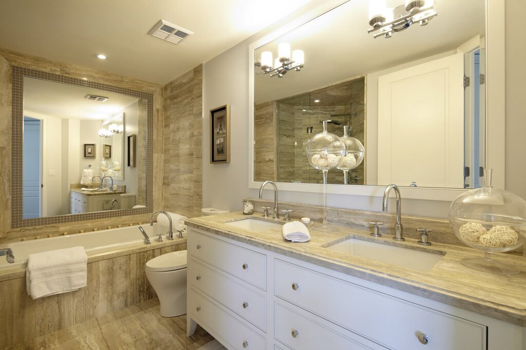 A bathroom with a large mirror above the sink