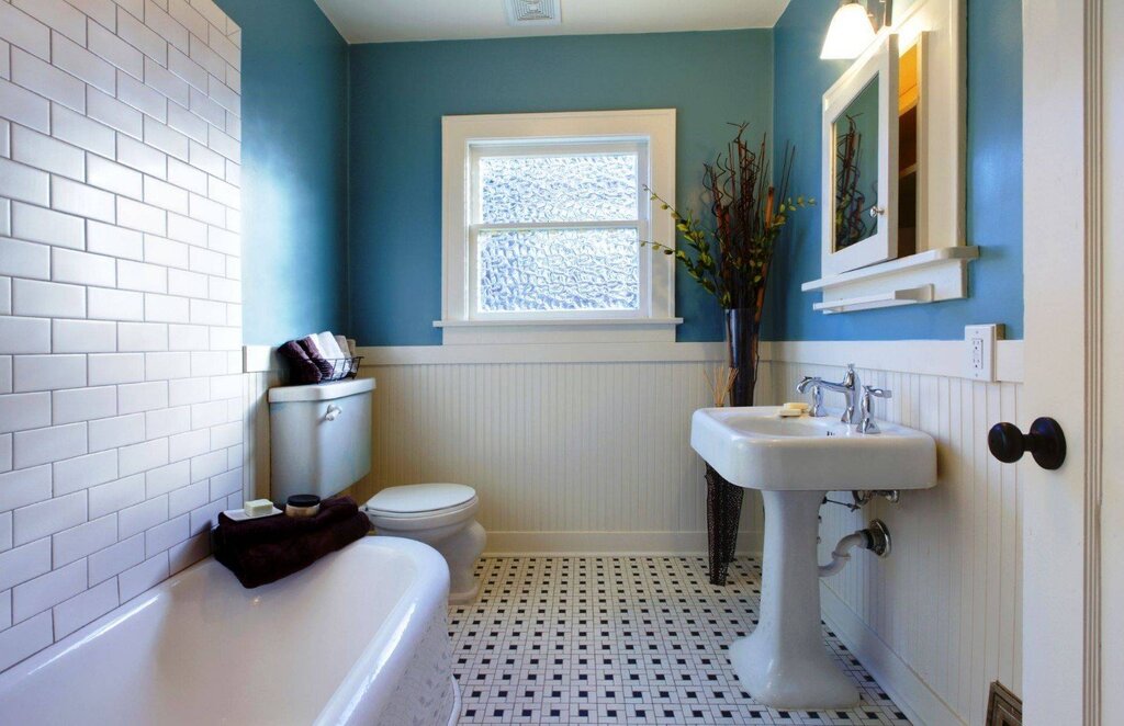 A bathroom with tiles up to the middle of the wall