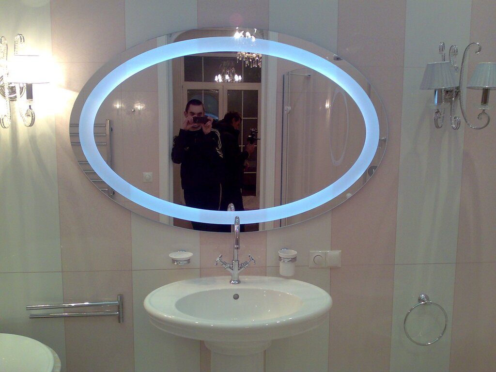 A semicircular mirror with lighting for the bathroom